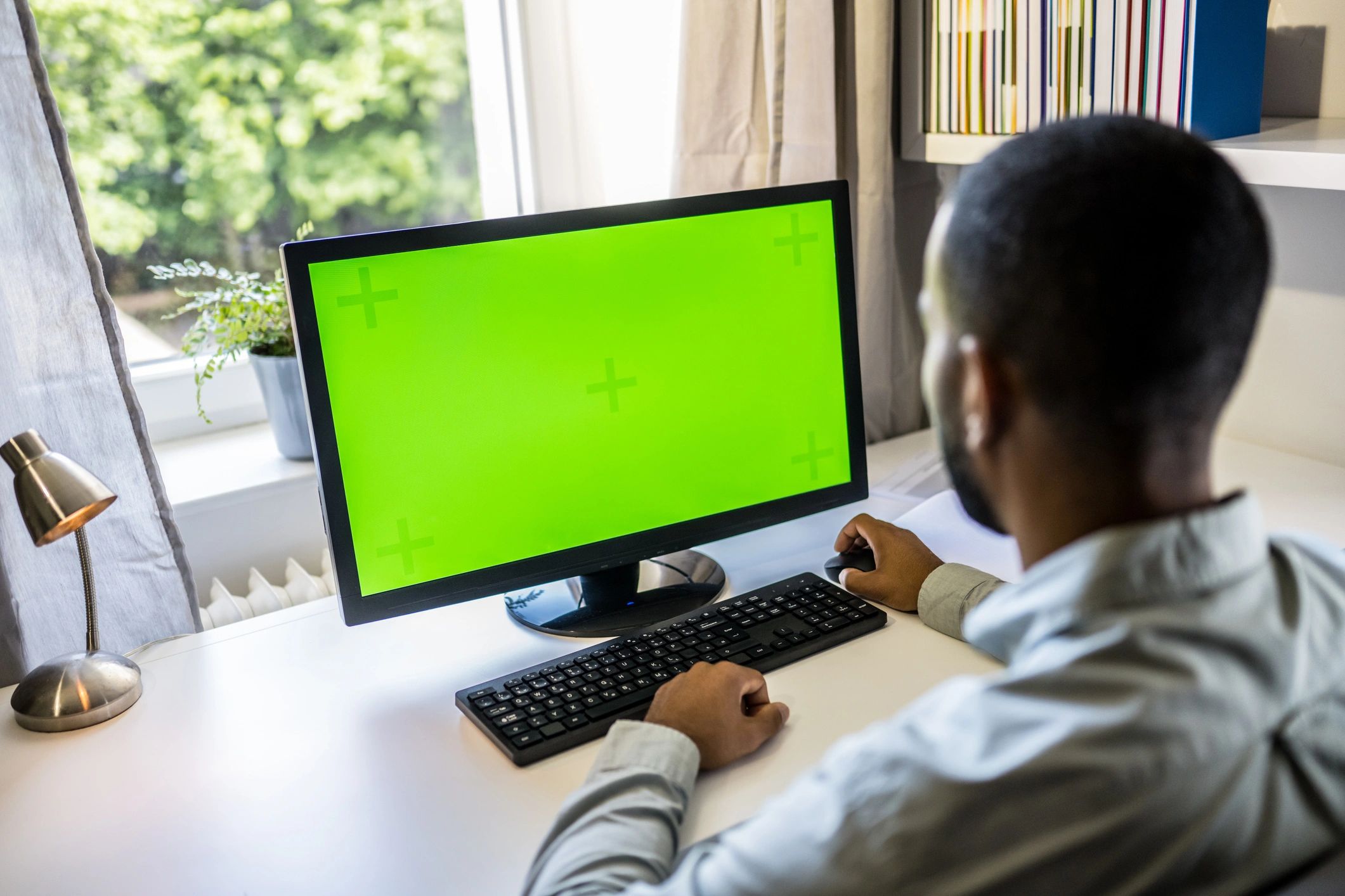Engineer working at a desk with a computer and prototype components