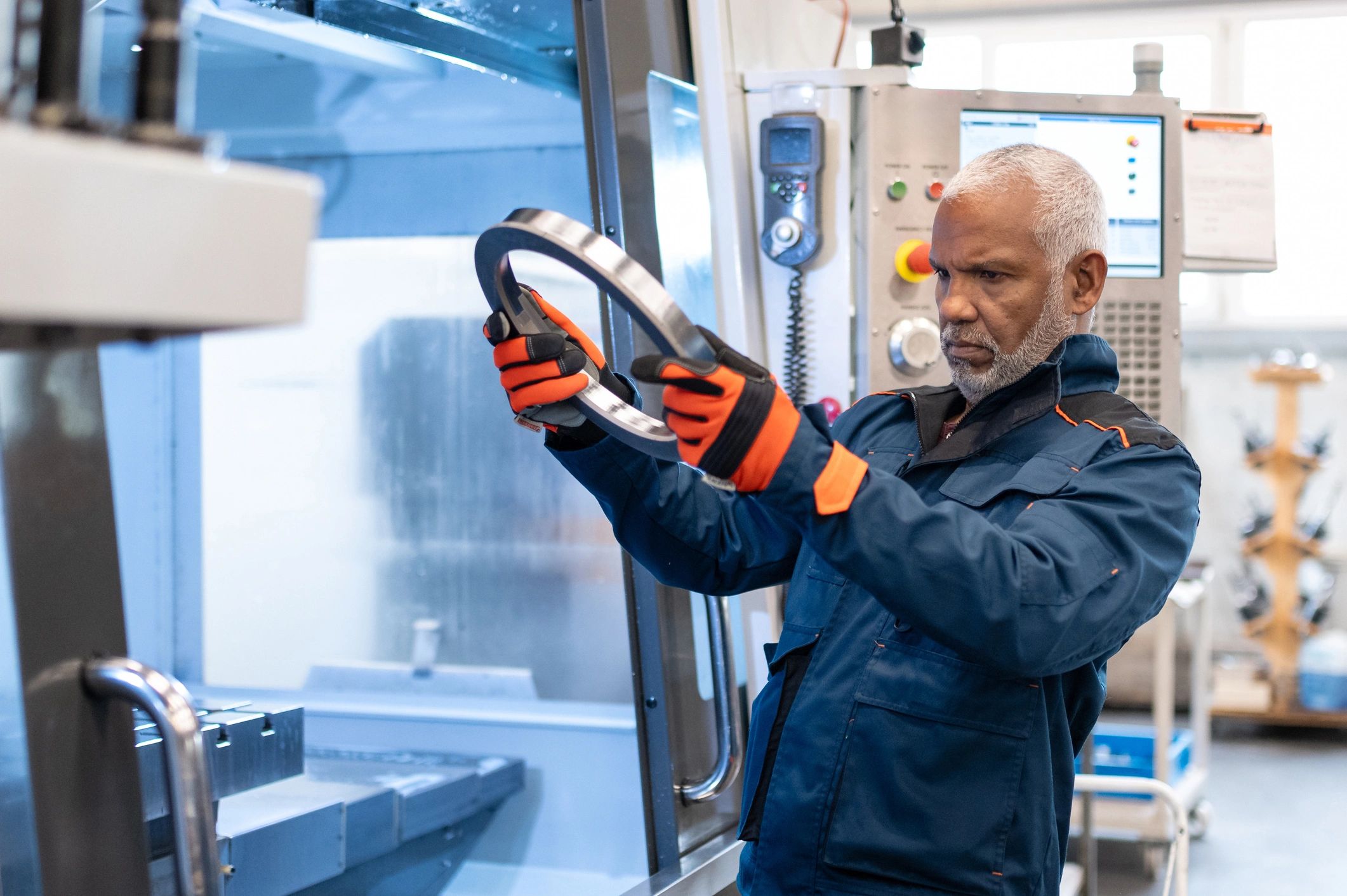 Mechanical engineer inspecting a machined component and comparing to drawings